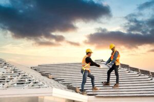 A person in an attic inspecting wooden roof decking for signs of water damage or mold.