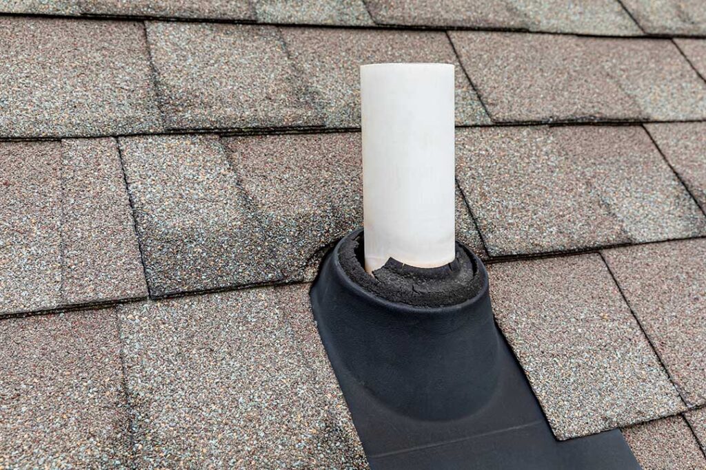 Workers shield a shingled roof with protective coverings while renovating an upper floor.
